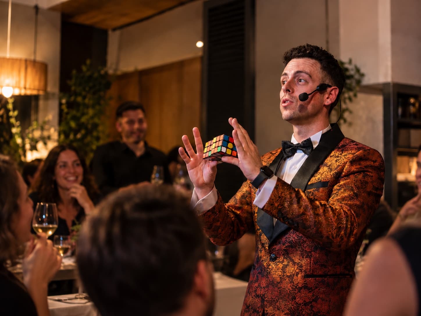 Alexander Main mostrant un cub de Rubik als assistents d'un sopar