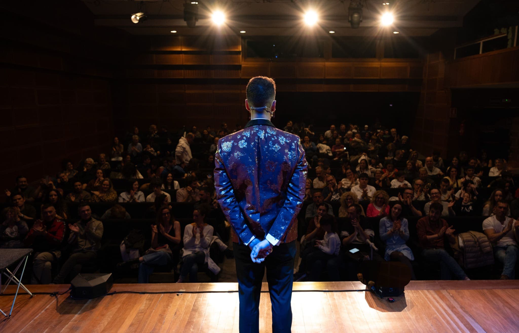 Alexander Main d'esquena a l'escenari davant del públic d'un auditori